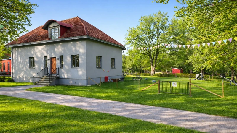 Ett litet vitt hus som står på en gräsmatta