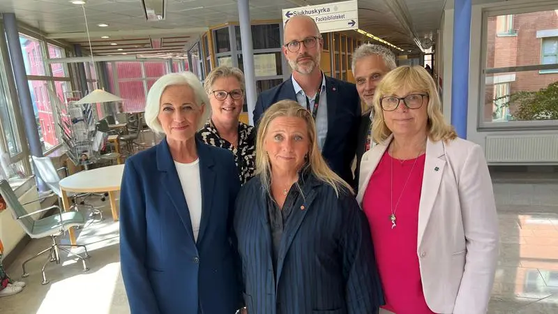 En grupp av sex personer står tillsammans i en ljus korridor på Visby lasarett.