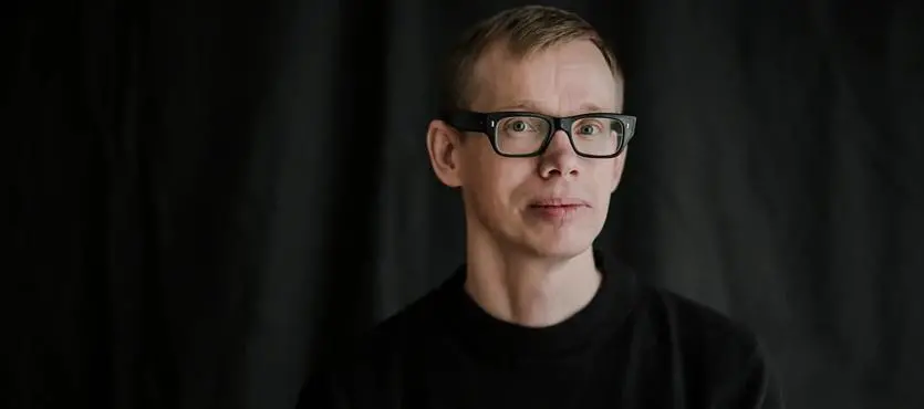 En man som bär glasögon och svart skjorta.