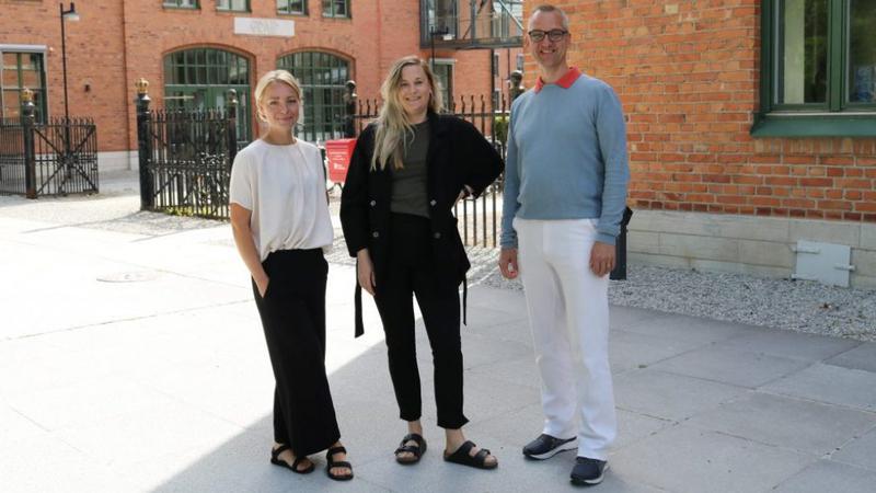 En grupp om tre personer som står bredvid varandra.