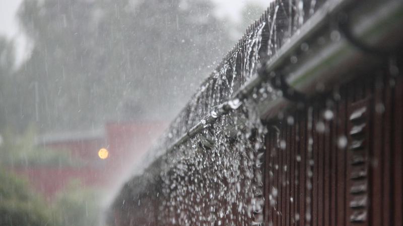 Regn forsar över hängränna