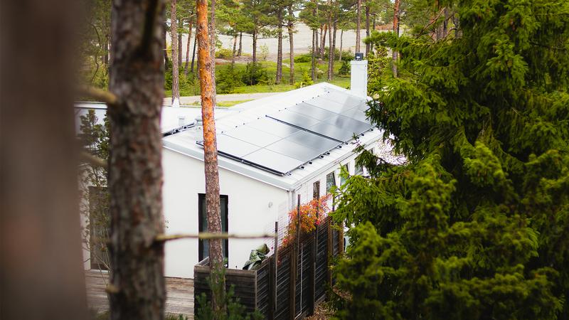 Ett hus med en solpanel på taket.