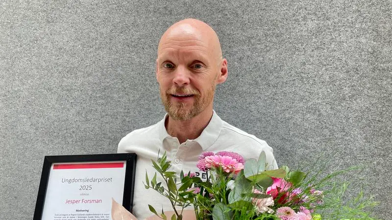 Jesper Forsman är glad och håller i diplom och blommor.