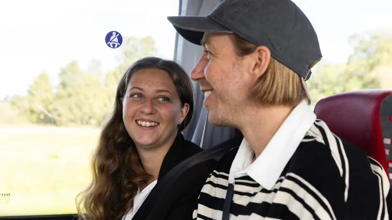 Två glada resenärer i en buss