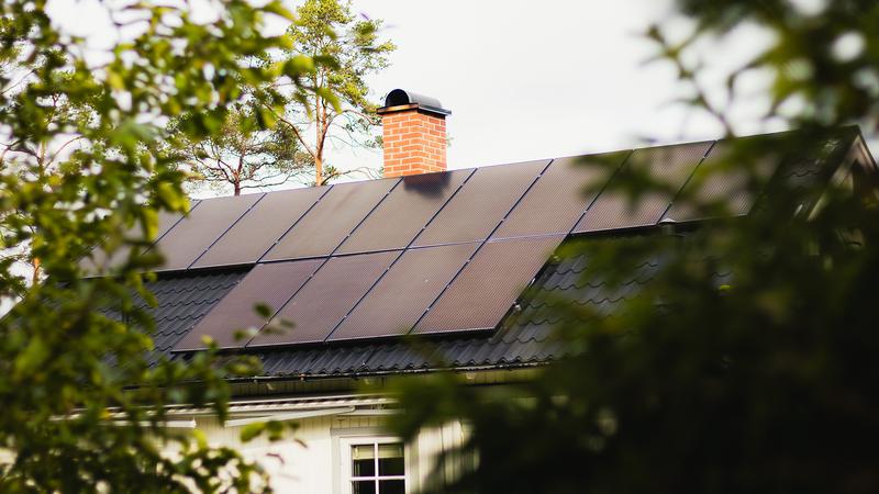 Ett hus med en solpanel på taket.