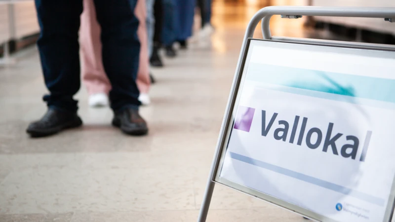 En skylt som säger vallokal framför en grupp människor.