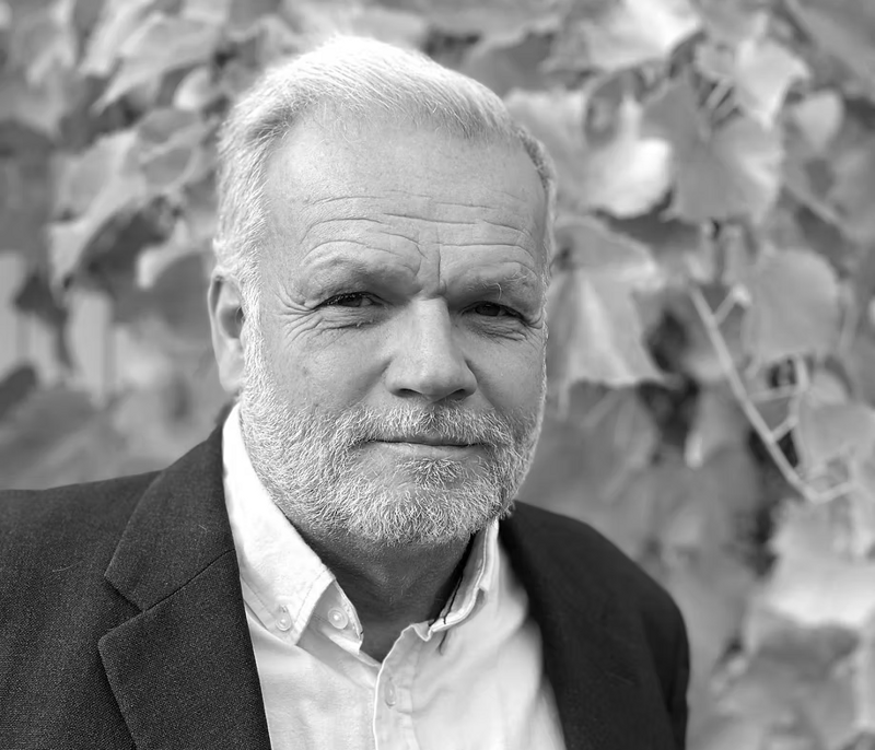 Ett svartvitt foto av en man i kostym.