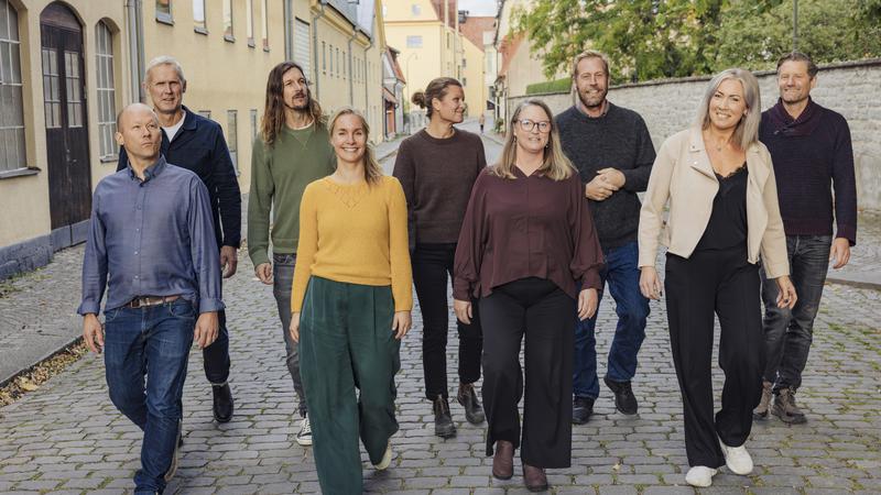 En grupp människor som går längs en kullerstensgata.