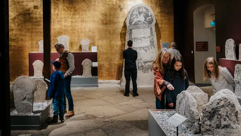 En grupp människor som står runt en museiutställning.