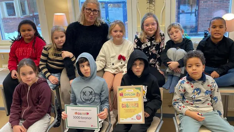 Yngre elever i klassrum med diplom i handen