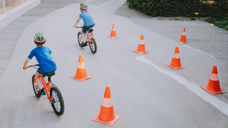 Några barn som cyklar genom en hinderbana.
