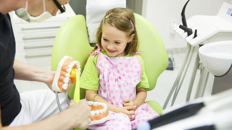 Bild på tandhygienist tillsammans med en ung patient 