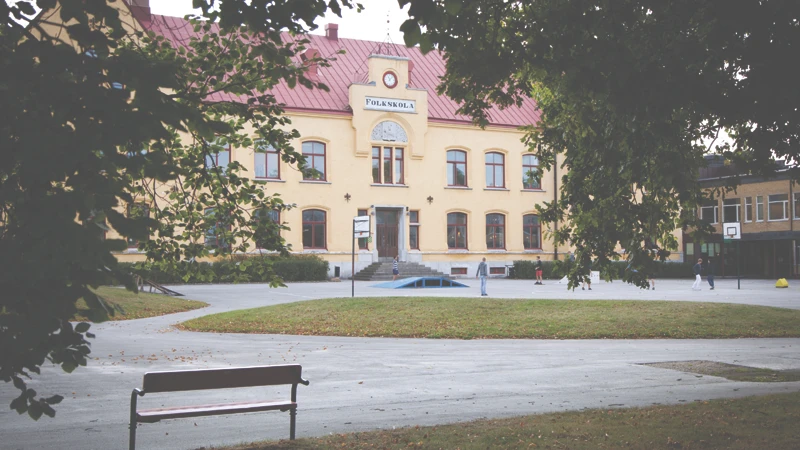 Skolgård med äldre skolbyggnad i bakgrunden