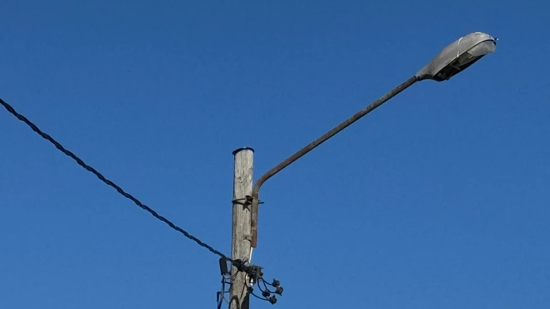 En telefonstolpe med en gatlykta på toppen.