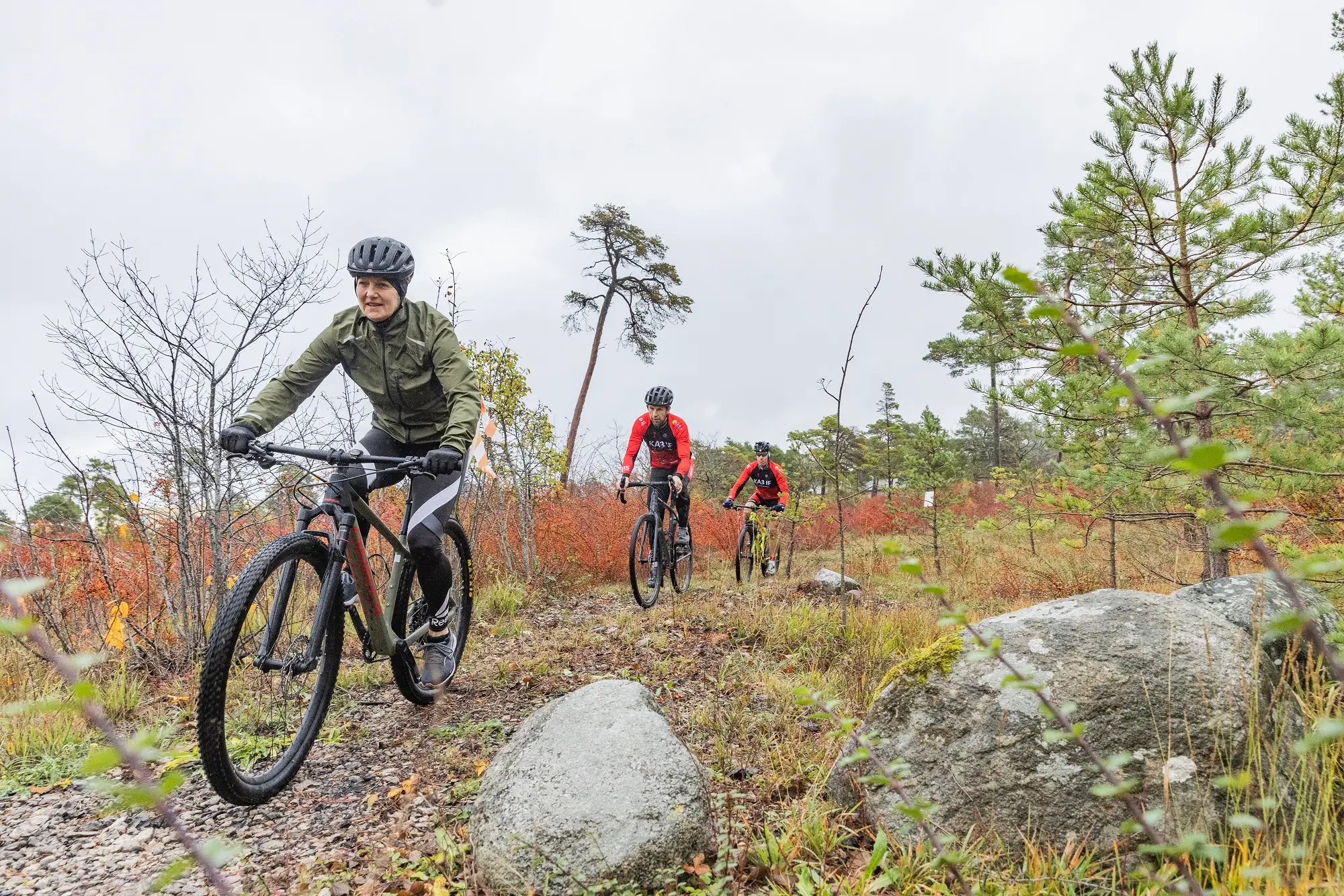 Cyklister i vildvuxen terräng