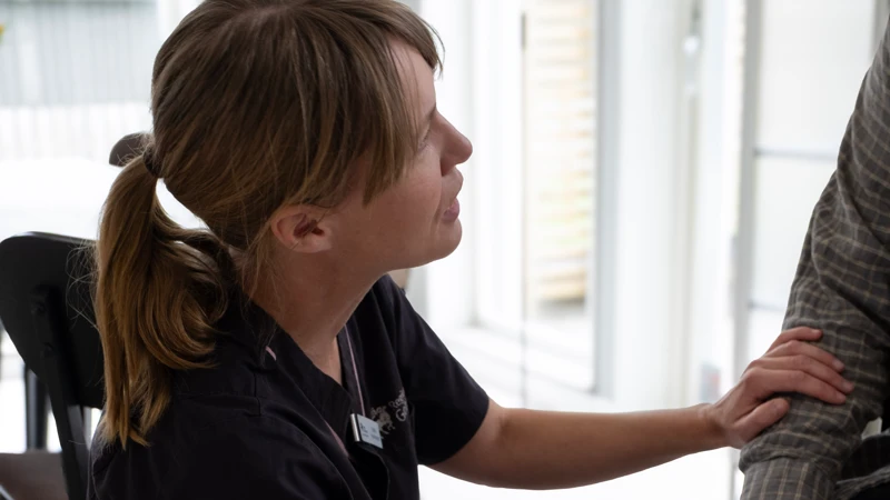 En kvinna som sitter på huk bredvid en man.