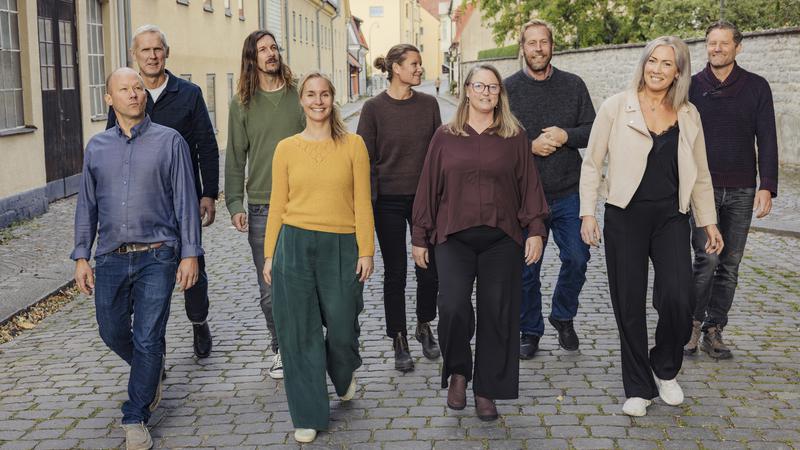 En grupp människor som går längs en kullerstensgata.