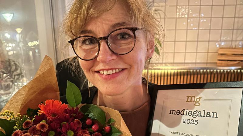 Bild på den kvinnliga pristagaren med blommor och diplom