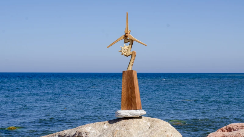 En staty  på toppen av en sten nära havet.