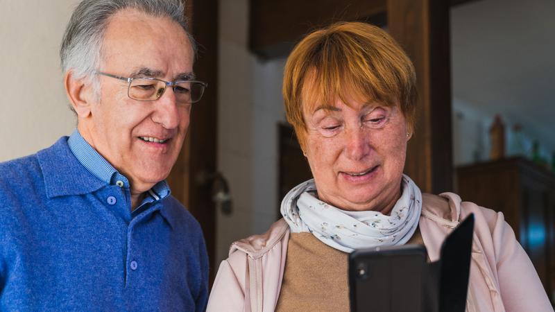 Äldre par som tittar i en mobiltelefon