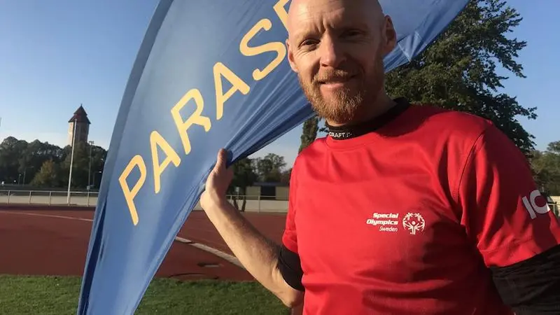En leende Jesper Forsman iklädd röd träningströja i löparspåret på Gutavallen i Visby. 
