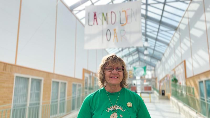 Iréne Rodebjer står framför plakat vid jubileum.