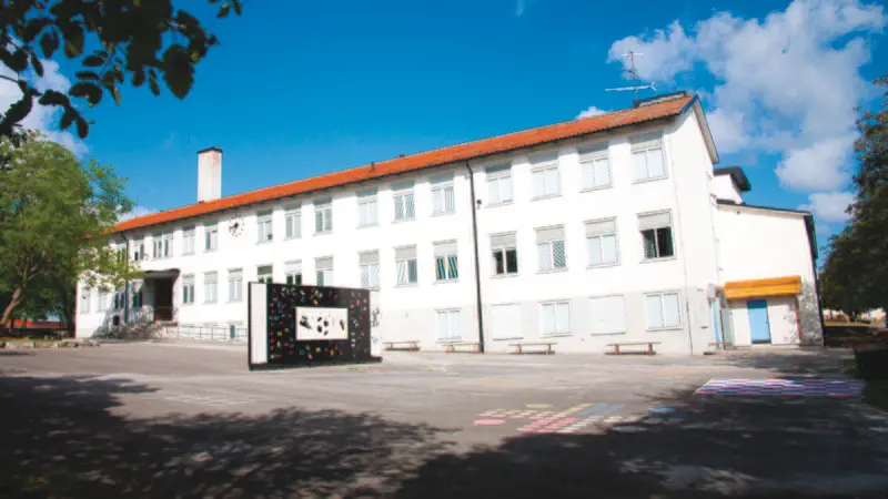 En vit trevåningsskolbyggnad.