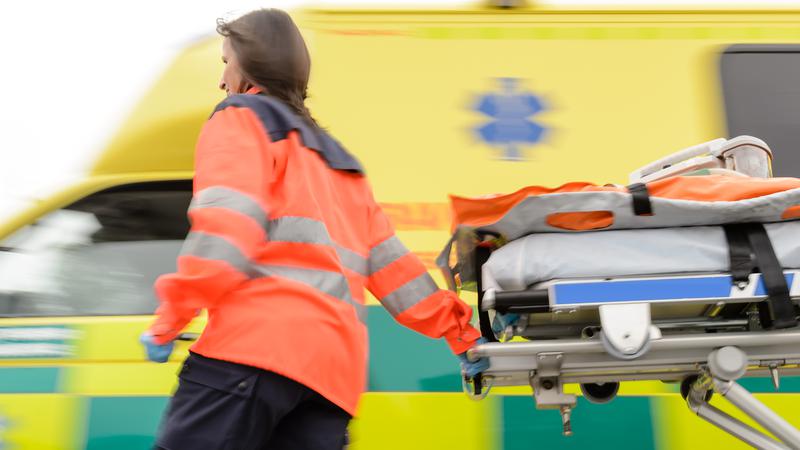 ambulans och springande kvinna med bår