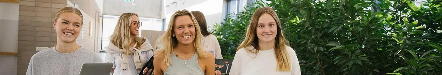 Glada gymnasielever i korridor 