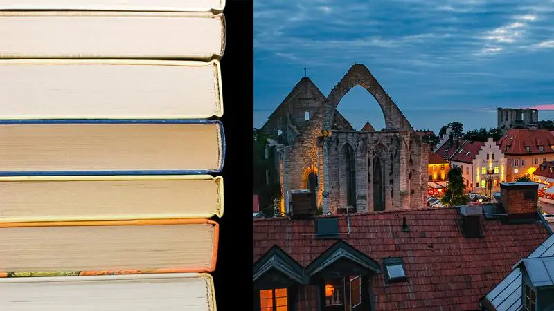 En trave böcker bredvid en bild på Visby innerstad kvällstid