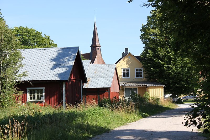 Längre bort, bakom några enstaka hus syns det ett kyrktak