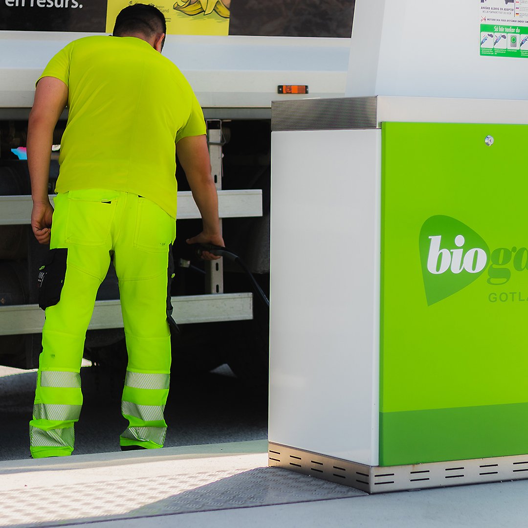 man i varselkläder tankar en lastbil med biogas