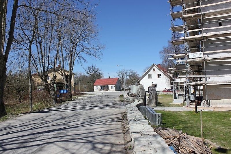 På höger sida av vägen pågår det en renovering av kyrkan, på vänster sida finns det en busshållplats.