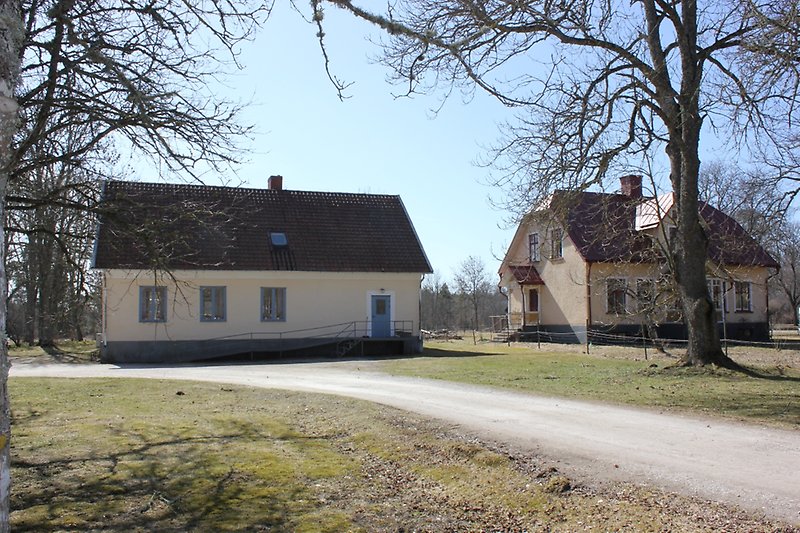 Två ljusrosa byggnader med röda tak.