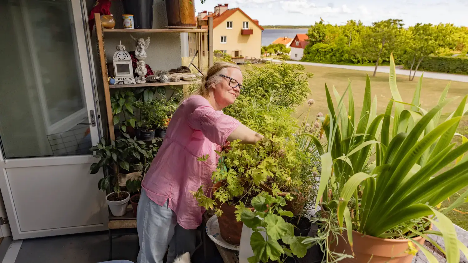 Kvinna tar hand om sina växter på en balkong