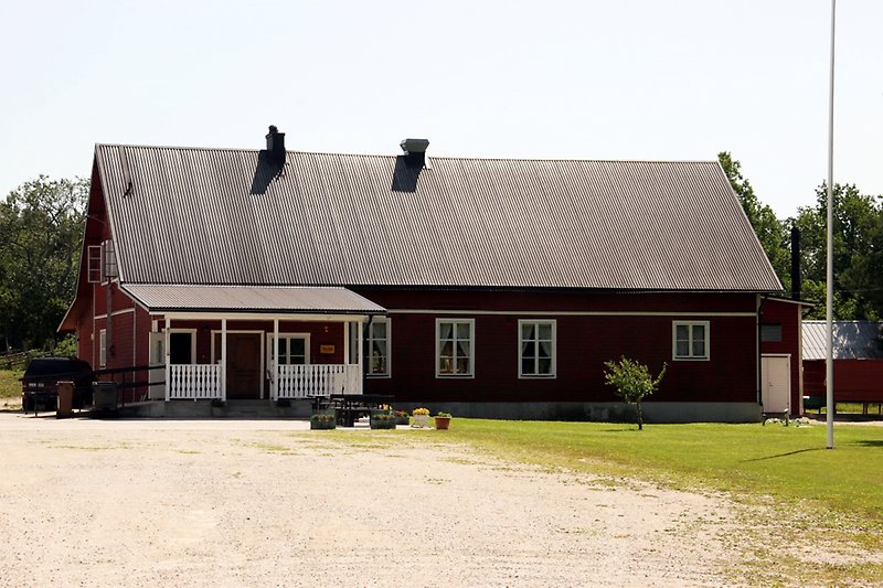 En röd envånings träbyggnad med ett svart plåttak.