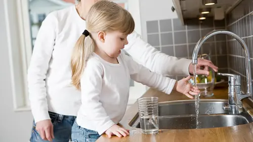 Flicka häller upp vatten