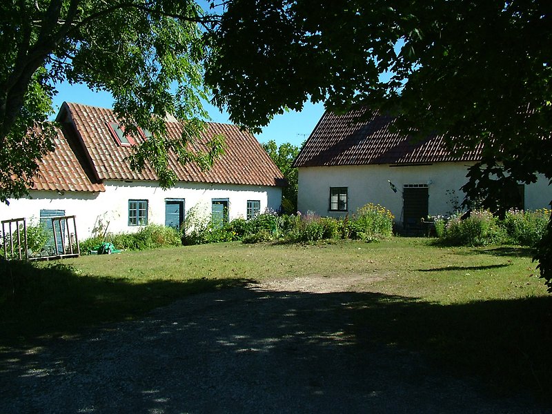 Flera vita hus med röda tak och skorstenar.