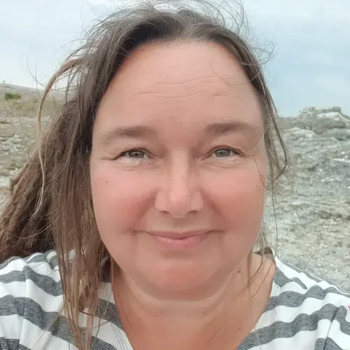 Medelålders kvinna med brunt hår i dreadlocks