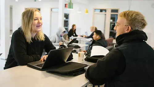Två personer samtalar i ett café