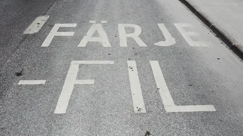 Närbild av markering i vägbanan för körfält som leder till bilfärja.